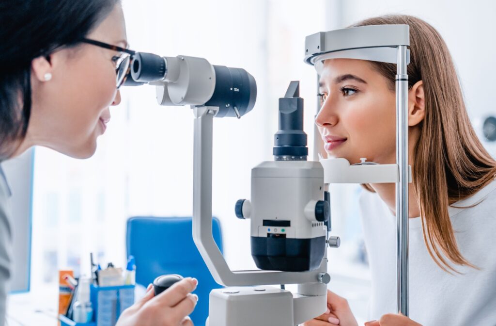 An eye doctor examining a patient's eyes for blepharitis symptoms worsened by eyelash extensions