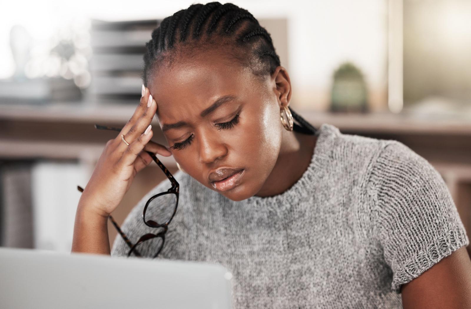 A person holding the side of their head after experiencing eye strain and anxiety.